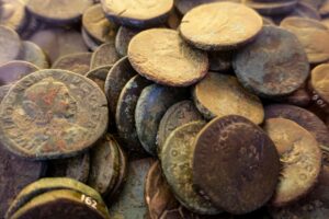 Close-up of weathered ancient Roman coins displaying rich textures and patinas, symbolizing history and archaeology.