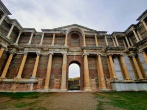 Stunning ancient Roman temple facade with brick and columns under a blue sky.
